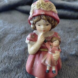 Charming Vintage Girl Figurine w/ Doll. Bell Design On Bottom W/ Dangling Legs.